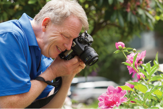 Man taking pictures of flowers in garden