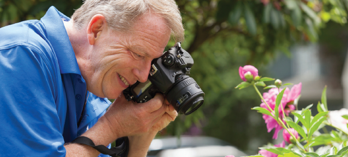 Man taking pictures of flowers in garden