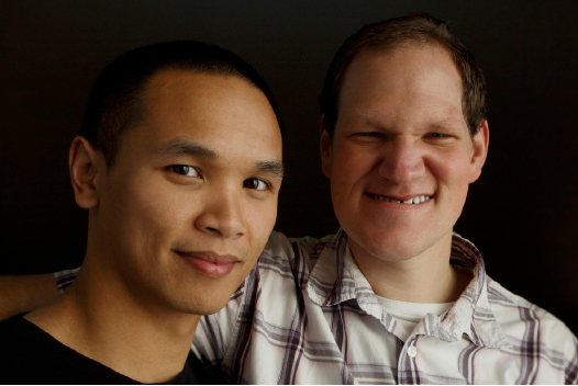 Two men smiling at camera.