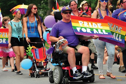 Man in wheelchair participating in Pride Parade