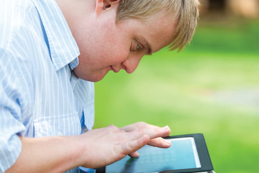 Young man playing on tablet in the park